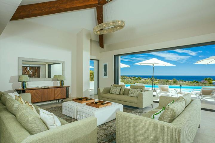 Open living room at Casa Alba with sofas and wide sliding doors to the pool terrace
