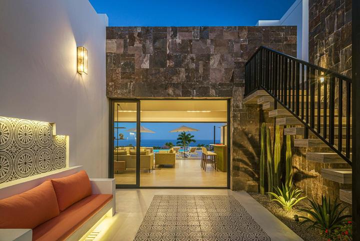 Entry courtyard at Casa Alba with a stone feature wall, built-in bench and view through to the living room