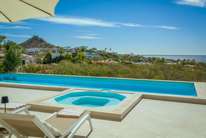 Jacuzzi and infinity pool at Casa Alba overlooking hillside homes and the coast