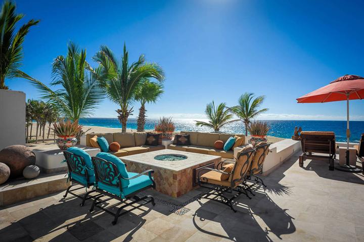 Fire-pit lounge with turquoise armchairs on the oceanfront terrace at Casa Alcini