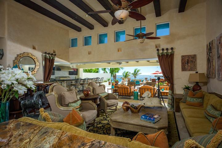 Double-height living room at Casa Alcini with exposed beams, clerestory windows and plush seating