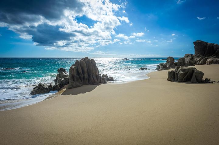 Granite boulders on the sandy Pacific beach near Casa Alcini