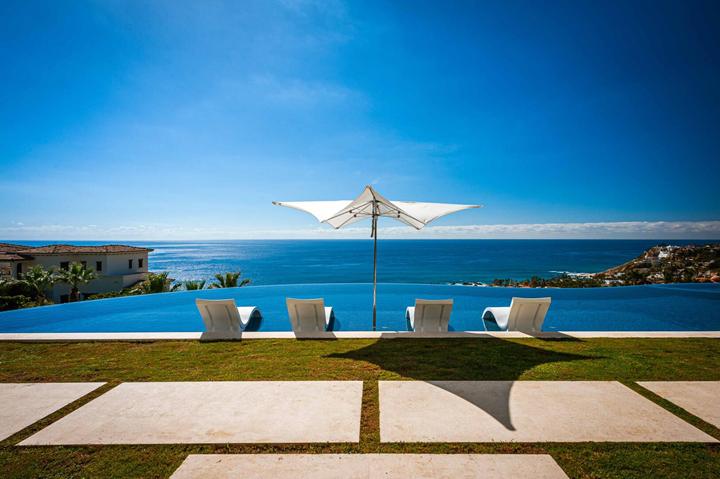 Lawn, loungers and umbrella at the edge of the infinity pool at Casa Catrina
