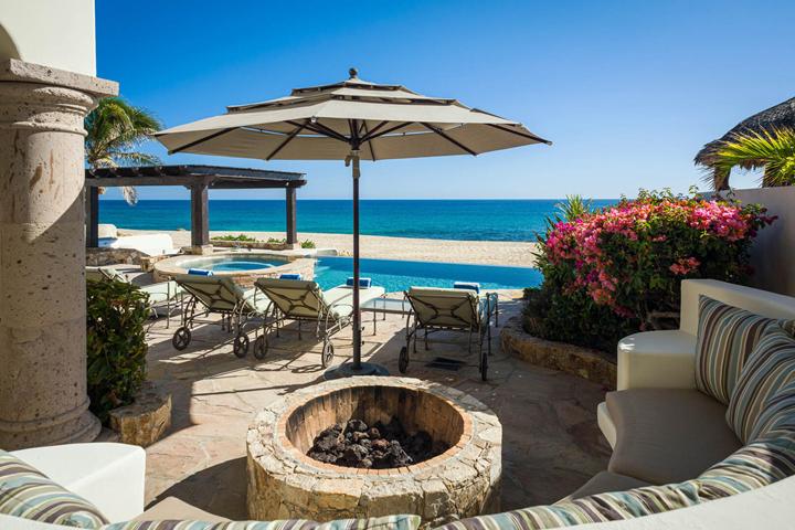 Fire-pit lounge with striped cushions overlooking the pool and sea at Casa Cielo