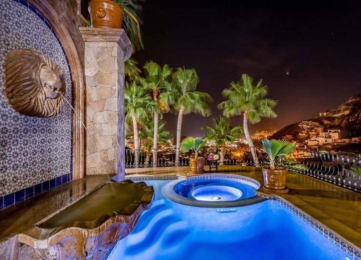 Illuminated Jacuzzi beside a tiled fountain wall at night at Casa Connie