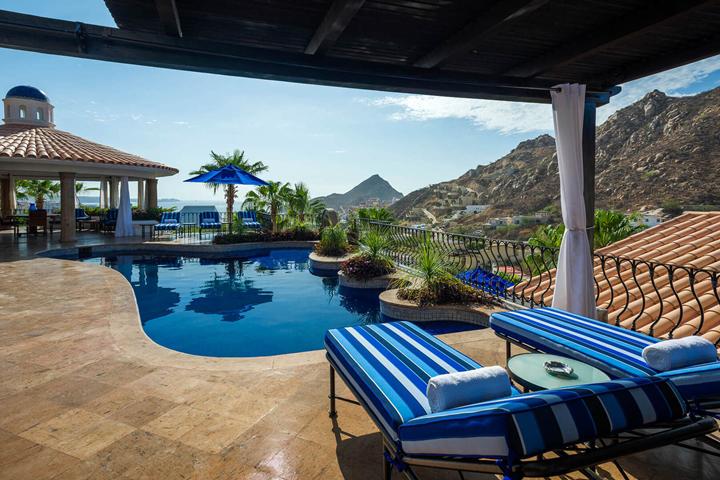 Covered lounge with striped loungers beside the pool at Casa Connie