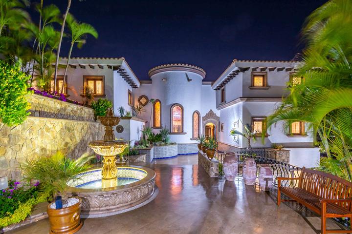 Courtyard fountain and arched entry lit at night at Casa Connie