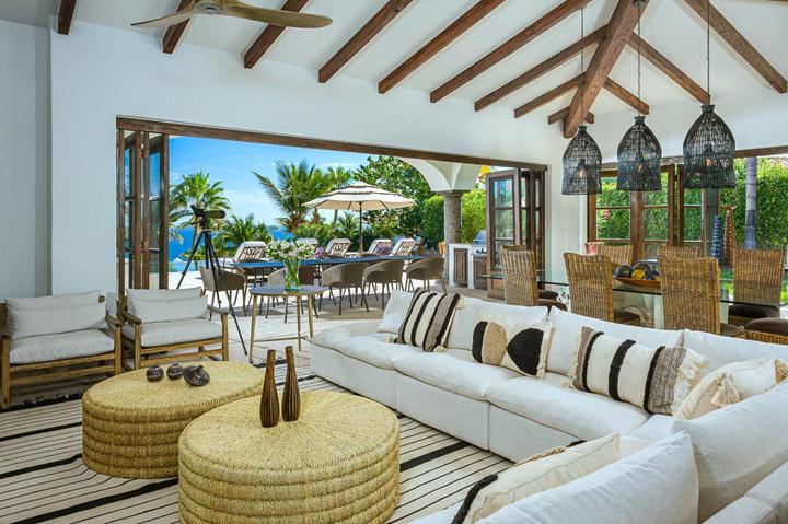 Great room with beamed ceiling and white sectional opening to the terrace at Casa de las Risas