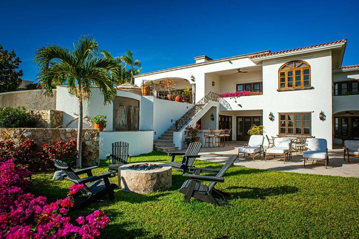Lawn with fire pit, Adirondack chairs and bougainvillea behind Casa de las Risas