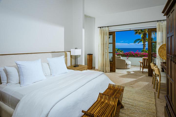 Bedroom with crisp white bedding and doors to a terrace at Casa de las Risas