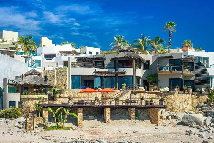 Casa del Arco seen from the beach, with its terraces and palapa