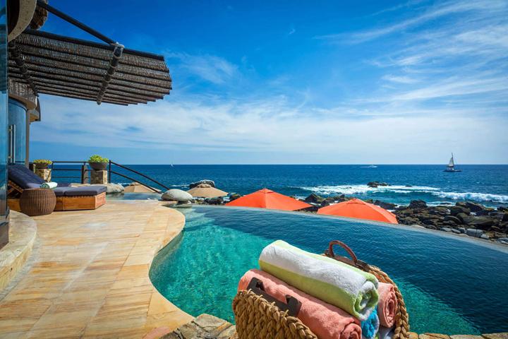 Pool deck with beach towels and ocean views at Casa del Arco