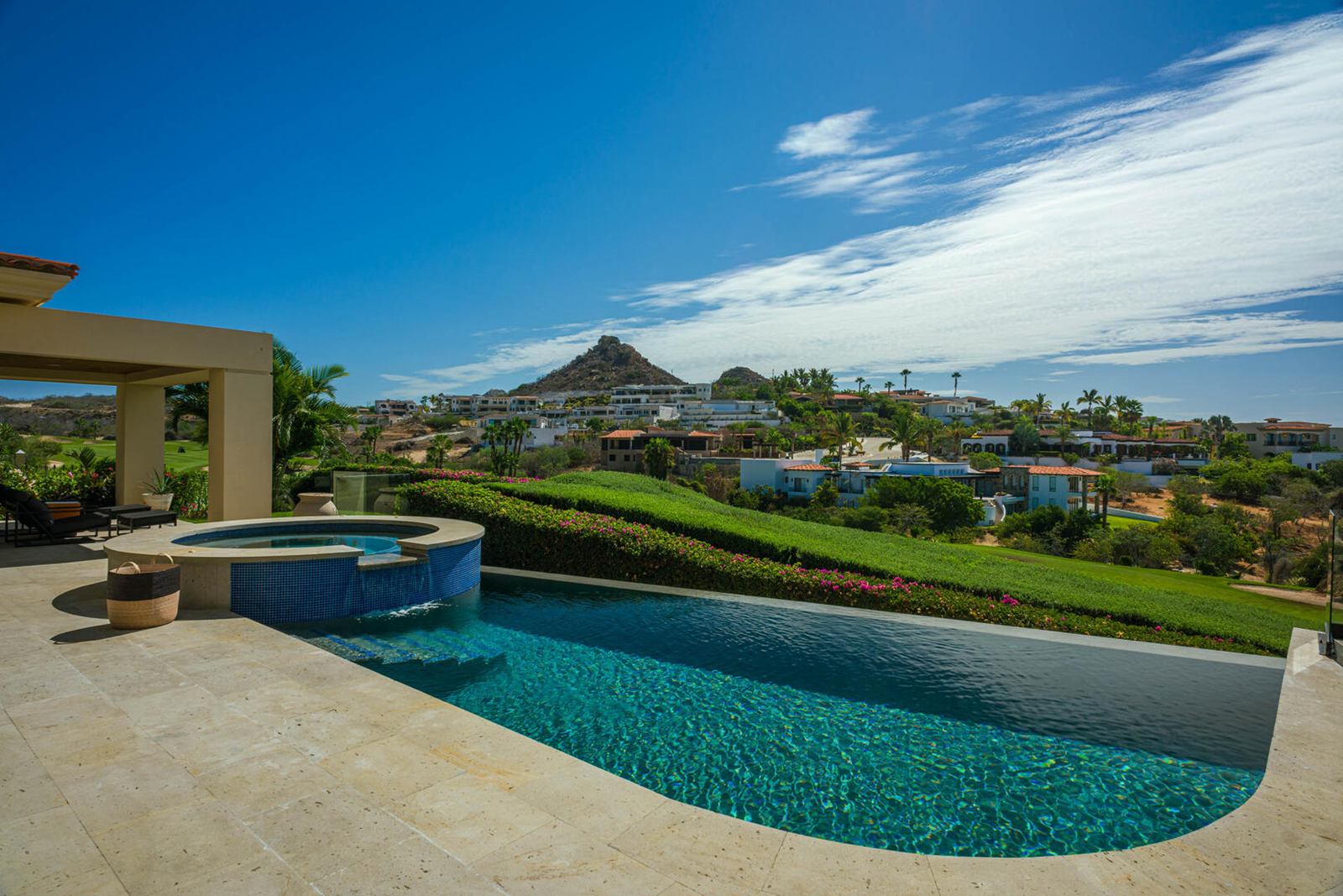 Infinity pool and Jacuzzi overlooking green fairways and hills in Puerto Los Cabos
