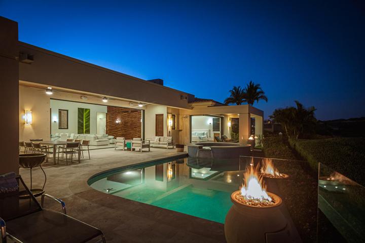 Casa Isabelle at night with fire bowls glowing beside the pool