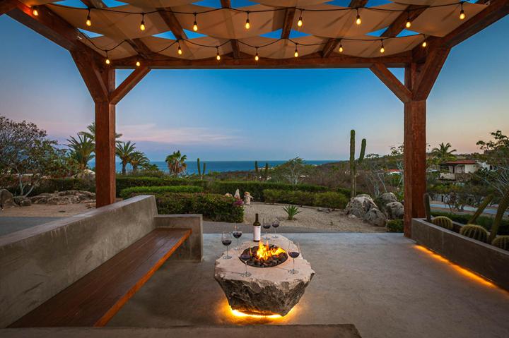 Fire pit under a string-lit pergola at dusk at Casa Isabelle