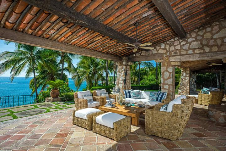 Covered stone loggia with lounge seating at Casa Koll Estate