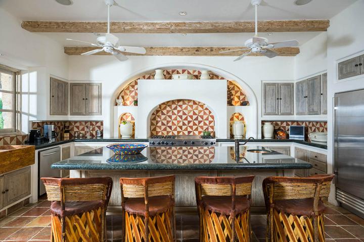 Villa kitchen with tiled hood, island and wood-beamed ceiling