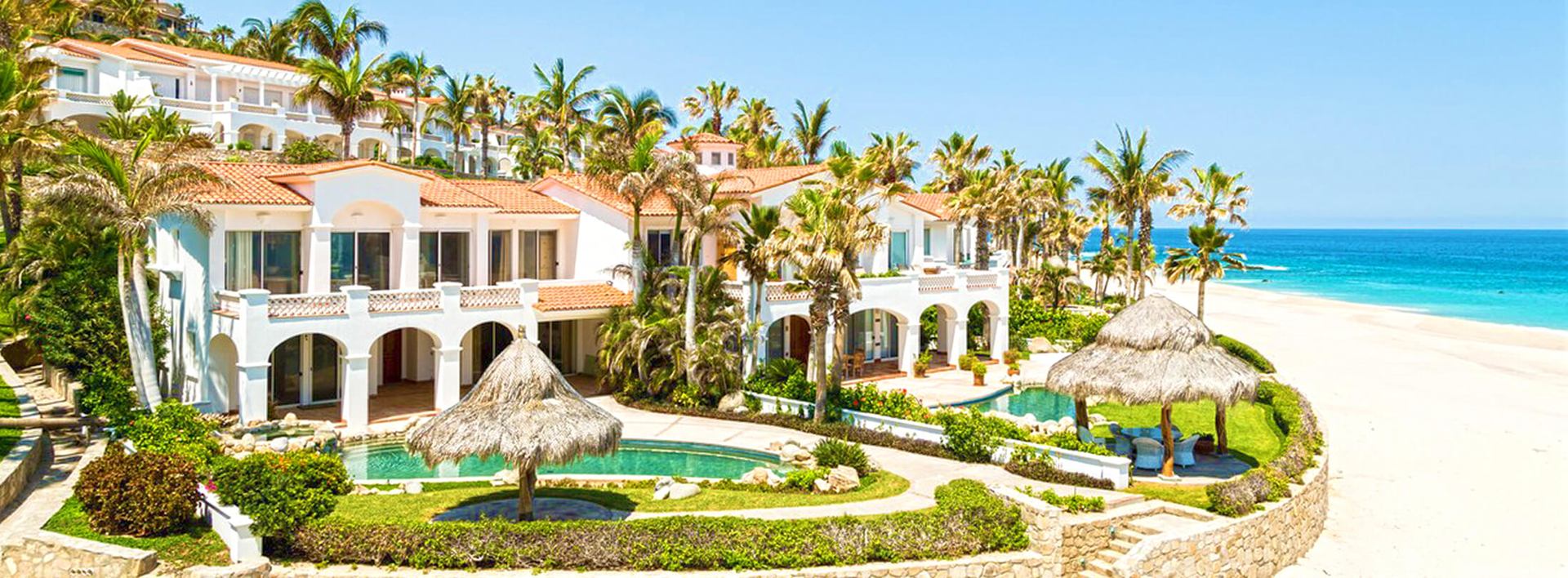 Beachfront grounds at Casa Koll Estate in Palmilla, with pools, palapas and palm gardens
