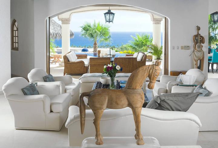 Sitting room with a view through an arch to the sea at Villa Buena Vida