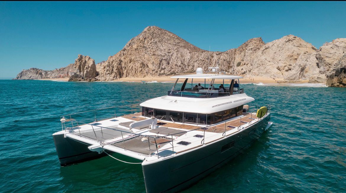 Luxury catamaran on turquoise water near the Land's End cliffs in Cabo San Lucas